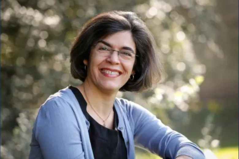 Photo of Kia Nobre wearing pale blue cardigan against a blurry background